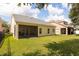 A view of the home's screened lanai with a well maintained lawn at 14741 Sapodilla Dr, Orlando, FL 32828