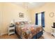 Bright bedroom features a decorative quilt, side tables with lamps, and a window with sheer blue curtains at 14741 Sapodilla Dr, Orlando, FL 32828
