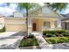 Charming yellow home featuring a manicured lawn, a two-car garage, and inviting front porch at 14741 Sapodilla Dr, Orlando, FL 32828