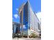 Modern, high rise condominium featuring a curved facade with glass windows and balconies on a sunny day at 155 S Court Ave # 2008, Orlando, FL 32801