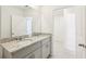 Bathroom featuring a double sink vanity with granite countertop and a connecting door to a bedroom at 1737 Forest Run Ln, Auburndale, FL 33823