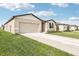 Well-maintained home featuring a manicured lawn, driveway, and neutral color scheme at 1737 Forest Run Ln, Auburndale, FL 33823