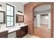 Bathroom with a dual vanity, brick accents, a window, and views into another room at 1741 Palmer Ave, Winter Park, FL 32789