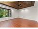 Bedroom with wood floors, a tray ceiling, and a large window with a backyard view at 1741 Palmer Ave, Winter Park, FL 32789