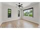Bright bedroom featuring wood floors, large windows with black trim, and a ceiling fan at 1741 Palmer Ave, Winter Park, FL 32789