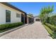 Long gravel driveway and tidy, trimmed green hedges and stucco exterior of home at 1741 Palmer Ave, Winter Park, FL 32789