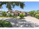 An estate home features a tile roof, a paved driveway, mature landscaping, and a private gate at 1741 Palmer Ave, Winter Park, FL 32789