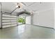 Bright and airy two-car garage with speckled epoxy flooring and view to driveway at 1741 Palmer Ave, Winter Park, FL 32789