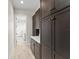 Hallway featuring dark wood cabinets with white countertops, bright white walls and wood floors at 1741 Palmer Ave, Winter Park, FL 32789