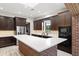 Gourmet kitchen featuring an island with cooktop and seating, stainless appliances, and brick accents at 1741 Palmer Ave, Winter Park, FL 32789