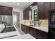 Modern kitchen featuring sleek dark wood cabinets, quartz countertops, stainless steel appliances, and stylish backsplash at 1741 Palmer Ave, Winter Park, FL 32789