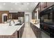 Modern kitchen with dual sinks, dark cabinetry, stainless appliances, light countertops, and brick accents at 1741 Palmer Ave, Winter Park, FL 32789