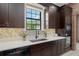 Beautiful kitchen with dark wood cabinetry, stainless steel appliances, quartz countertops, and a mosaic tile backsplash at 1741 Palmer Ave, Winter Park, FL 32789