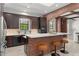 Kitchen with dark cabinets, light countertops, brick island with seating, and views of the living space at 1741 Palmer Ave, Winter Park, FL 32789