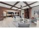 Open-concept living room featuring brick accents, wood beams, fireplace, and seamless access to the kitchen at 1741 Palmer Ave, Winter Park, FL 32789