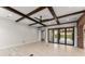 Open living room featuring wood beams, modern fan, and sliding glass doors to an outdoor space at 1741 Palmer Ave, Winter Park, FL 32789