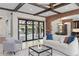 Living room with beamed ceilings, sliding doors to the patio, and an open flow to the dining room at 1741 Palmer Ave, Winter Park, FL 32789