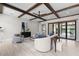 Open-concept living room with wood beams, neutral furnishings, leading to an outdoor patio through sliding doors at 1741 Palmer Ave, Winter Park, FL 32789