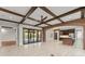 Open living room featuring exposed wood beams, brick archways, and sliding glass doors to outdoor living space at 1741 Palmer Ave, Winter Park, FL 32789