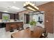 Open-concept living area featuring a brick archway, breakfast bar, wood floors, and modern furnishings at 1741 Palmer Ave, Winter Park, FL 32789