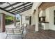 Inviting outdoor kitchen and patio with brick flooring, solar panel roof, and comfortable wicker furniture at 1741 Palmer Ave, Winter Park, FL 32789