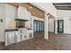 Covered patio with brick floor and a built-in stainless steel outdoor kitchen with a grill at 1741 Palmer Ave, Winter Park, FL 32789