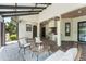 Inviting outdoor kitchen and patio with brick flooring, solar panel roof, and comfortable wicker furniture at 1741 Palmer Ave, Winter Park, FL 32789
