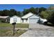 Charming single-Gathering home with a well-manicured front yard, brick driveway, and an attached two-car garage at 2009 Nottingdale Ln, Winter Park, FL 32792