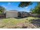 The backyard has a screened-in lanai and mature trees providing shade and beauty at 2028 Donegan Pl, Orlando, FL 32826