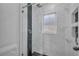 Beautiful shower with glass enclosure, white marble-look tile, dark accent tile, and a shower niche at 2028 Donegan Pl, Orlando, FL 32826