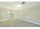 Neutral bedroom with new flooring, fresh paint, a large window, and baseboard trim at 2028 Donegan Pl, Orlando, FL 32826