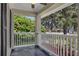 Serene front porch with white railing and views of lush greenery, ideal for enjoying the neighborhood at 2028 Donegan Pl, Orlando, FL 32826