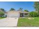 Charming single-story home with a well-maintained lawn and a two car garage and a clear blue sky at 2028 Donegan Pl, Orlando, FL 32826