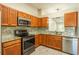 Open kitchen view featuring stainless steel appliances, tile backsplash, and wood-grain cabinets at 2028 Donegan Pl, Orlando, FL 32826