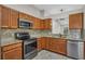 Well-appointed kitchen with wood cabinets, granite countertops, and stainless steel appliances at 2028 Donegan Pl, Orlando, FL 32826