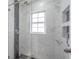 Updated bathroom with a glass shower door, a rainfall shower head, and tiled walls at 2028 Donegan Pl, Orlando, FL 32826
