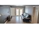 Inviting living room with doors to a private balcony, neutral walls, and wood-look tile at 204 E South St # 4056, Orlando, FL 32801