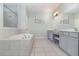 Spacious bathroom featuring a soaking tub, double vanity, and tile flooring at 2061 Rush Bay Way, Orlando, FL 32824