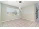 Bright dining room with tile floors, natural light from a large window, and modern chandelier at 2061 Rush Bay Way, Orlando, FL 32824