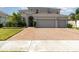 Stunning two-story home boasts a brick driveway and lush landscaping at 2061 Rush Bay Way, Orlando, FL 32824