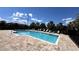 Community pool with ample lounge chairs on a sunny day at 2450 Sweet Viburnum Way, Ocoee, FL 34761