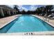 Sparkling community pool with marked depth, surrounded by lounge seating at 2450 Sweet Viburnum Way, Ocoee, FL 34761