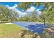 Community basketball court under a sunny sky, surrounded by grassy areas and mature trees at 2460 Worthington Rd, Maitland, FL 32751