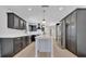 Bright kitchen featuring dark cabinets, a large island, stainless steel appliances, and modern lighting at 2460 Worthington Rd, Maitland, FL 32751