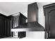 Close up of a modern stainless steel vent hood in the kitchen with black cabinetry at 2460 Worthington Rd, Maitland, FL 32751