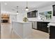Spacious kitchen with a large island, dark cabinets, stainless steel appliances, and modern light fixtures at 2460 Worthington Rd, Maitland, FL 32751