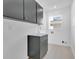 Practical laundry room features upper and lower gray cabinets and a sink at 2460 Worthington Rd, Maitland, FL 32751
