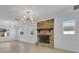 Bright living room featuring a brick fireplace, modern lighting, and newly refinished hardwood floors at 2460 Worthington Rd, Maitland, FL 32751