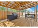 Covered wooden deck featuring built-in grill and patio set with privacy fence at 2460 Worthington Rd, Maitland, FL 32751