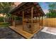 Outdoor wood patio with overhead roof, lighting, fan, outdoor kitchen, privacy fence and manicured landscaping at 2460 Worthington Rd, Maitland, FL 32751